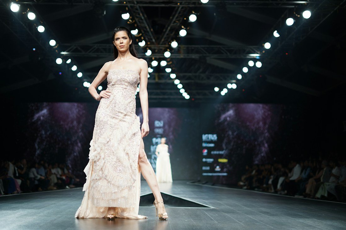 Fashion editorial: a runway model wearing an ivory dress
